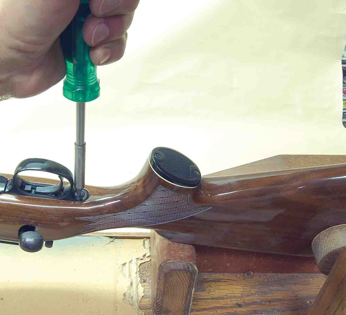 Removing a slotted guard screw requires clamping a rifle in a gun vise to prevent the screwdriver from slipping out of the screw slot.